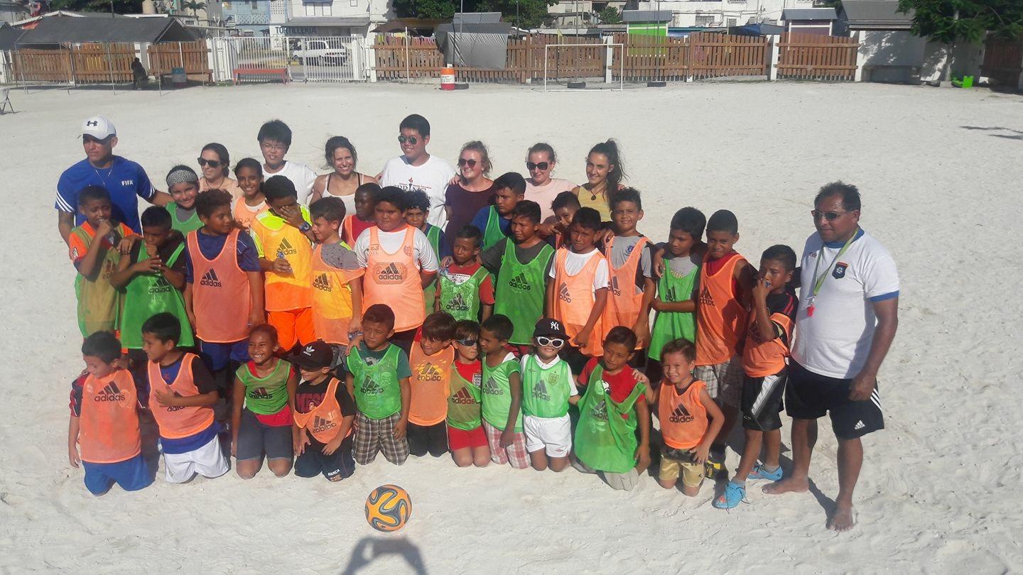 An instructor volunteering as a sports coach in schools in Belize poses with his team A Projects Abroad volunteer gets sports coaching work experience in Belize